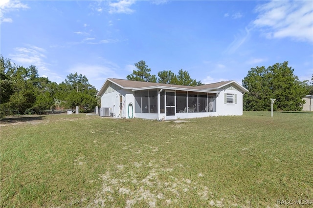 back of property with a yard, central AC unit, and a sunroom