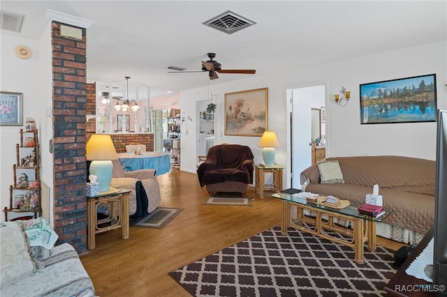 living room featuring a textured ceiling, ceiling fan with notable chandelier, and hardwood / wood-style flooring