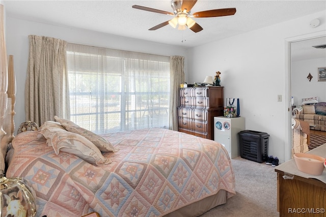 carpeted bedroom with a textured ceiling and ceiling fan