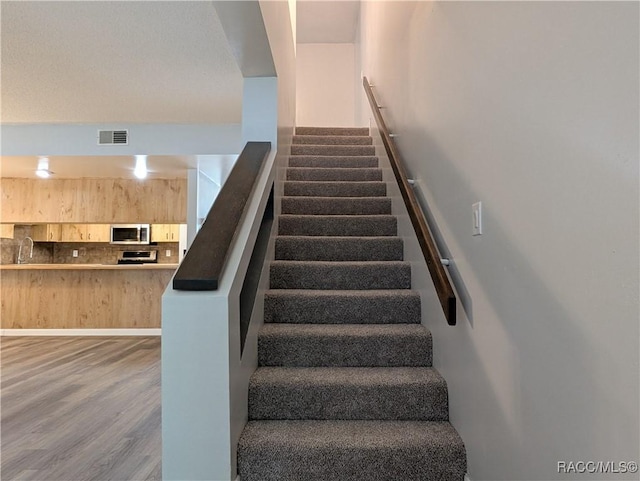 9781 E Goldfinch Ln, Inverness, FL 34450 - stairway featuring wood finished floors