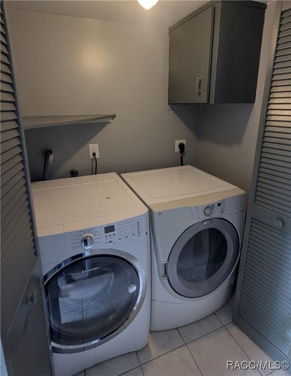 9781 E Goldfinch Ln, Inverness, FL 34450 - washroom featuring washer and clothes dryer, cabinet space, and light tile patterned flooring