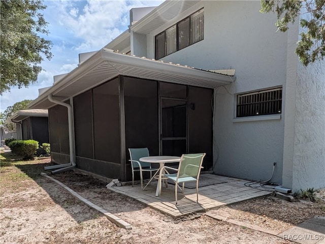 9781 E Goldfinch Ln, Inverness, FL 34450 - back of property with a sunroom, a patio area, and stucco siding