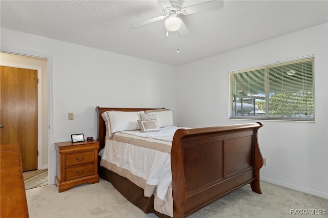 carpeted bedroom with ceiling fan and a textured ceiling