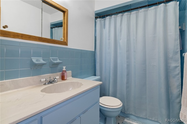 bathroom featuring curtained shower, vanity, tile walls, and toilet