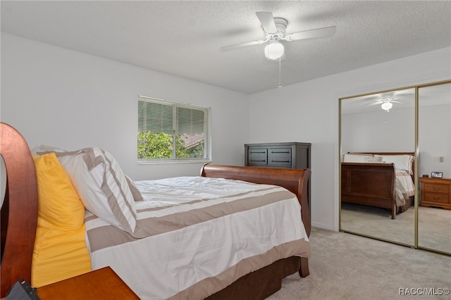 carpeted bedroom featuring ceiling fan, a textured ceiling, and a closet