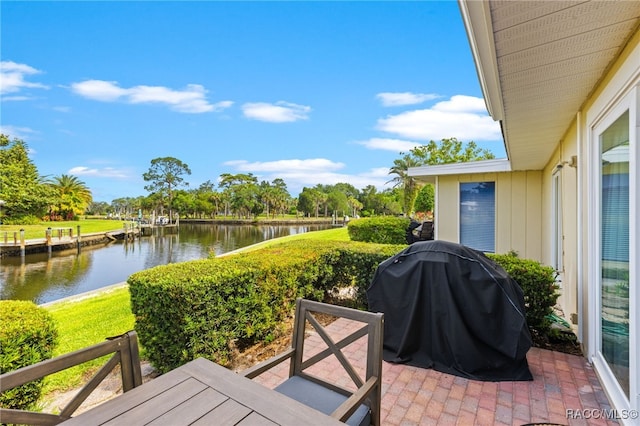 view of patio featuring a grill and a water view