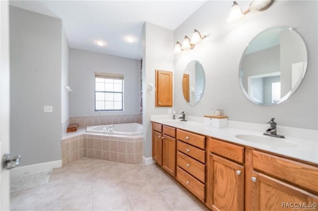 bathroom with tile patterned flooring, vanity, and tiled bath