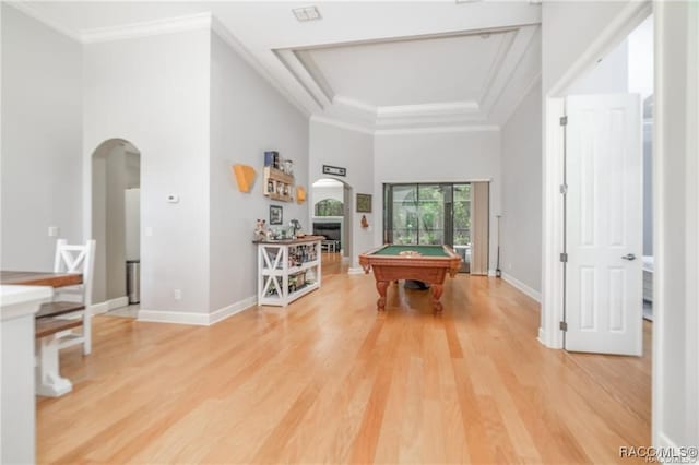 recreation room with hardwood / wood-style flooring, a raised ceiling, crown molding, and pool table