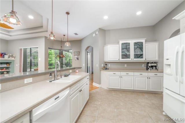 kitchen featuring white cabinets, pendant lighting, white appliances, and sink