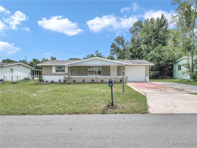 single story home with covered porch, a front yard, and a garage