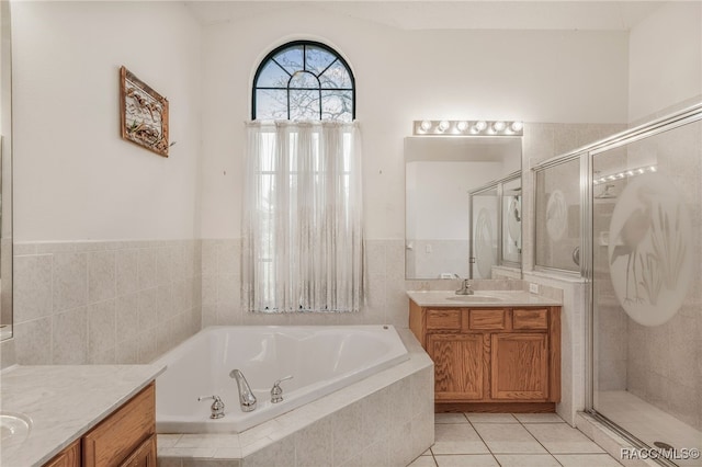 bathroom with a garden tub, two vanities, a sink, a shower stall, and tile patterned flooring