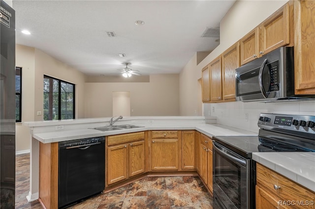 kitchen featuring visible vents, a sink, a peninsula, and black appliances