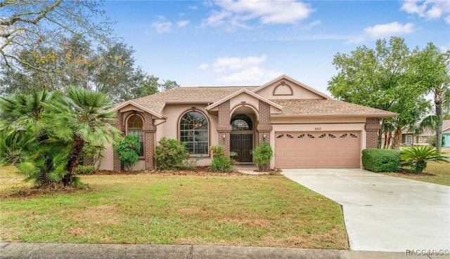 view of front of property with an attached garage, a front lawn, concrete driveway, and brick siding