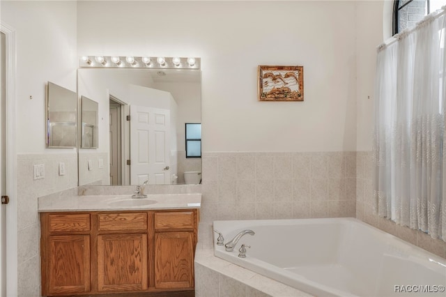 full bathroom with vanity, a bath, and tile walls