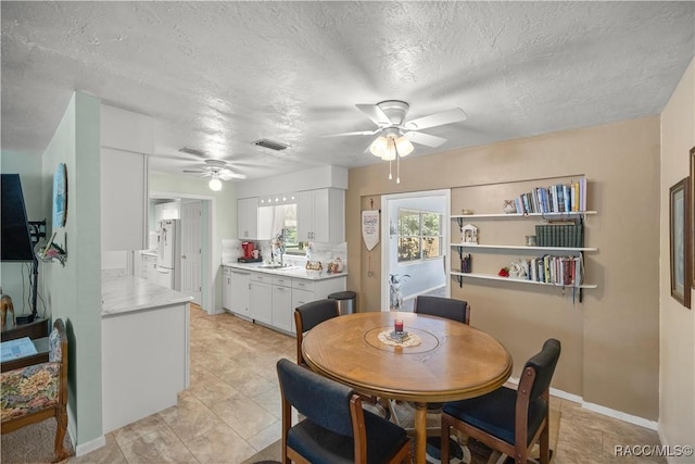 tiled dining space featuring a textured ceiling