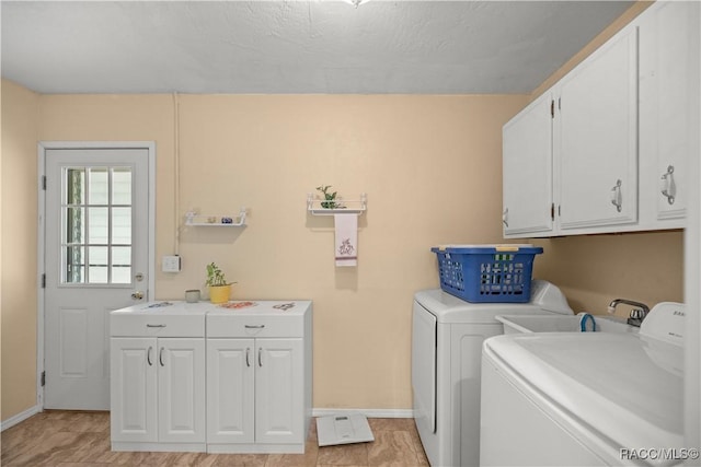 washroom featuring cabinets, independent washer and dryer, and light tile patterned floors