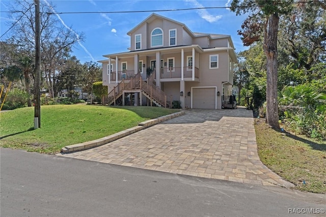 view of front facade featuring a garage, covered porch, and a front yard