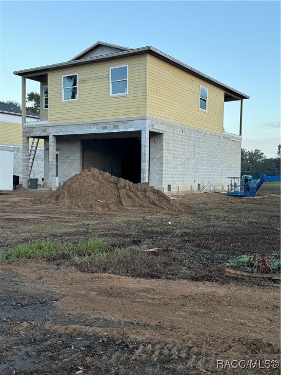 view of side of property with a garage and cooling unit