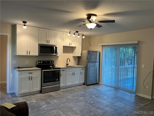 kitchen featuring ceiling fan, white cabinetry, sink, and appliances with stainless steel finishes