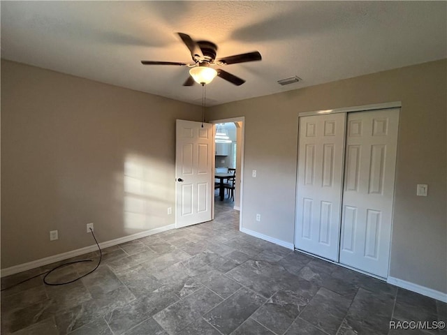 unfurnished bedroom featuring ceiling fan and a closet