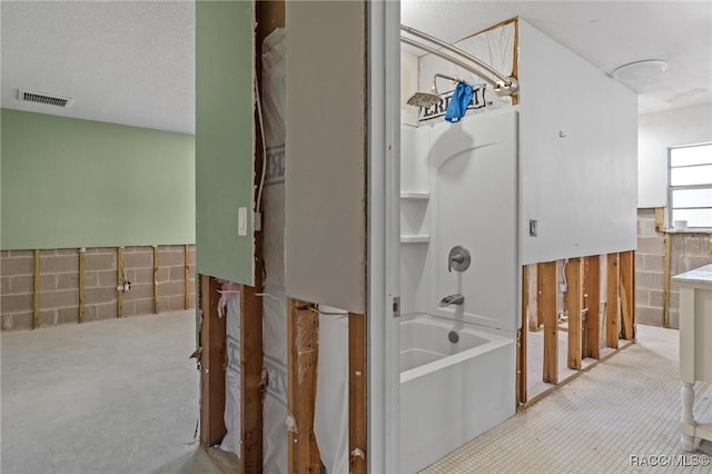 bathroom featuring tile walls, visible vents, wainscoting, and shower / bathing tub combination