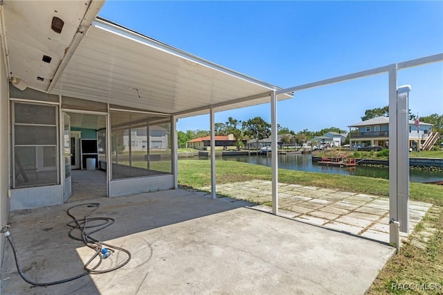 view of patio featuring a sunroom and a water view