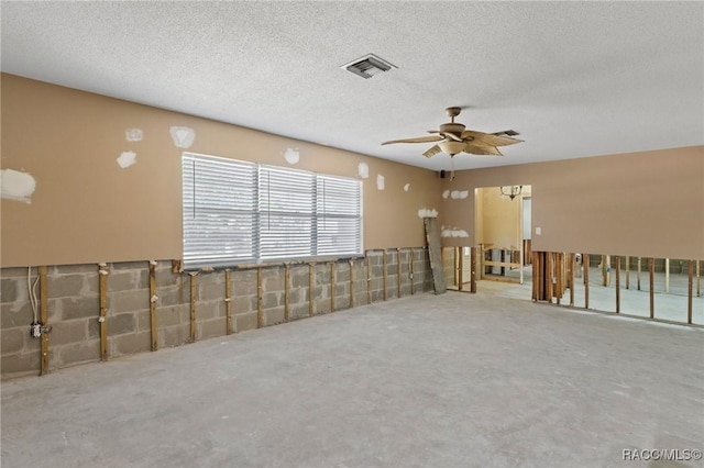 unfurnished room featuring visible vents, a ceiling fan, and a textured ceiling