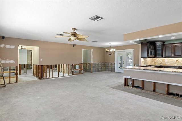 kitchen featuring stainless steel microwave, decorative backsplash, glass insert cabinets, visible vents, and dark brown cabinets