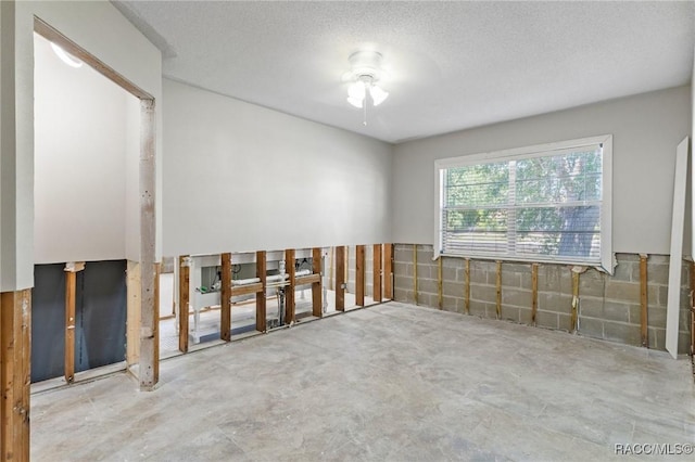 empty room featuring a textured ceiling and unfinished concrete flooring