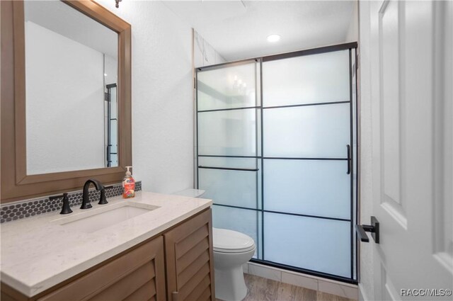 5079 W Pinto Loop, Beverly Hills, FL 34465 - bathroom with a stall shower, toilet, wood finished floors, and vanity