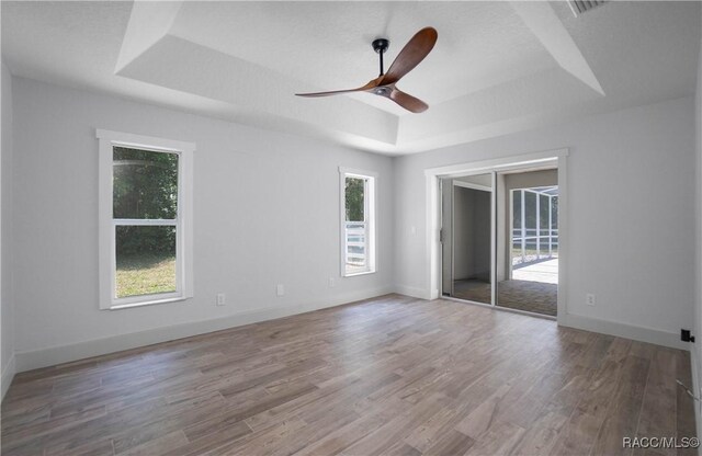 5079 W Pinto Loop, Beverly Hills, FL 34465 - unfurnished room featuring a raised ceiling, a ceiling fan, wood finished floors, and baseboards