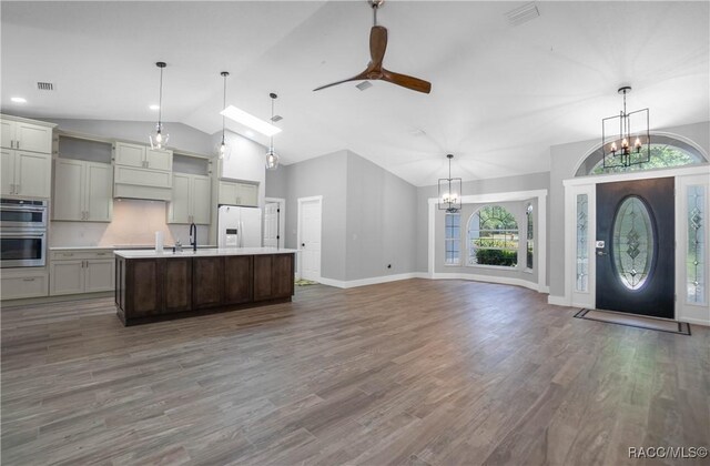 5079 W Pinto Loop, Beverly Hills, FL 34465 - kitchen featuring white refrigerator with ice dispenser, a chandelier, stainless steel double oven, healthy amount of natural light, and high vaulted ceiling