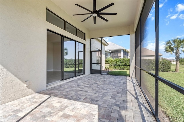 unfurnished sunroom with ceiling fan