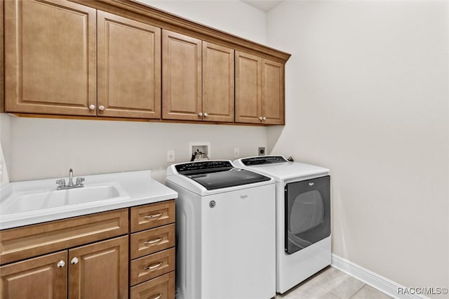 laundry room featuring cabinets, sink, light tile patterned flooring, and washing machine and clothes dryer