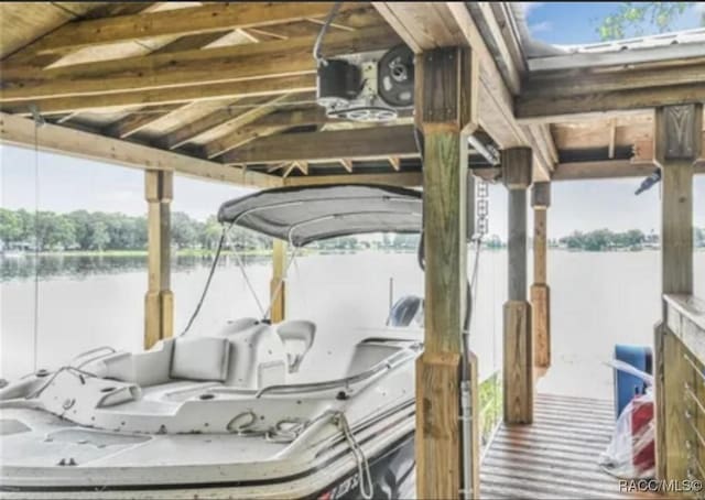 dock area featuring boat lift and a water view