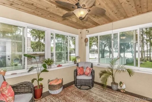 sunroom featuring wooden ceiling, plenty of natural light, and ceiling fan