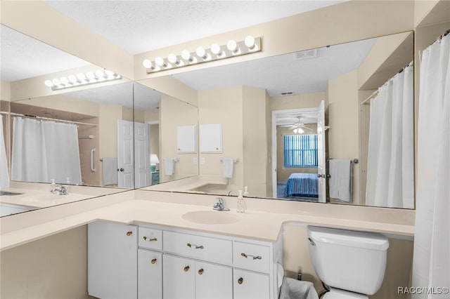 bathroom featuring vanity, ceiling fan, toilet, and a textured ceiling