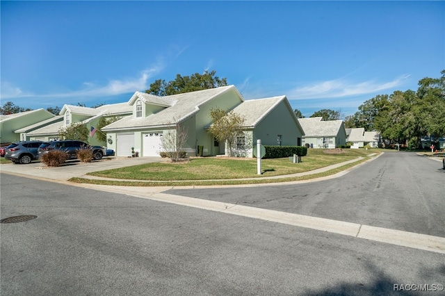 cape cod house featuring a front yard and a garage