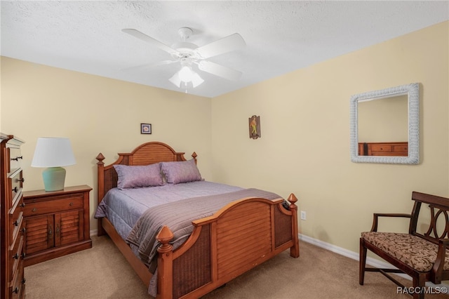 carpeted bedroom featuring ceiling fan and a textured ceiling