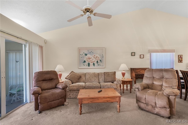 carpeted living room with ceiling fan and vaulted ceiling