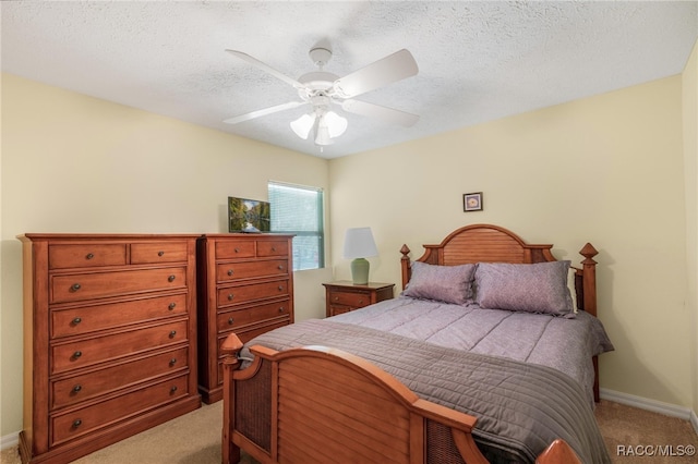 bedroom with a textured ceiling, light colored carpet, and ceiling fan