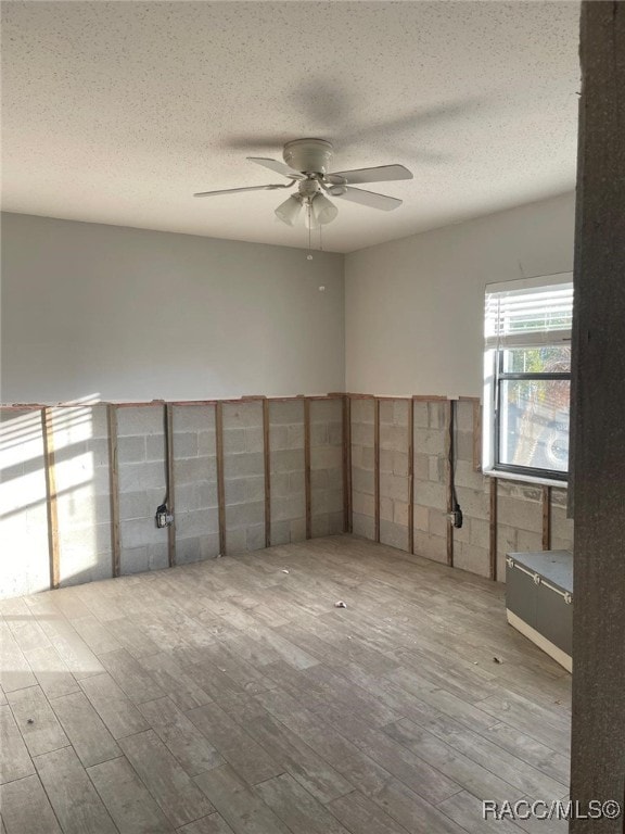 spare room featuring ceiling fan, a textured ceiling, and light hardwood / wood-style flooring