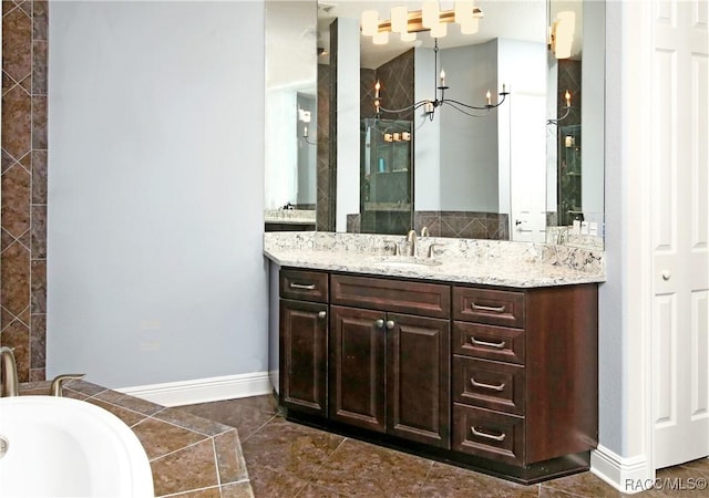 bathroom featuring vanity, a tub to relax in, and an inviting chandelier