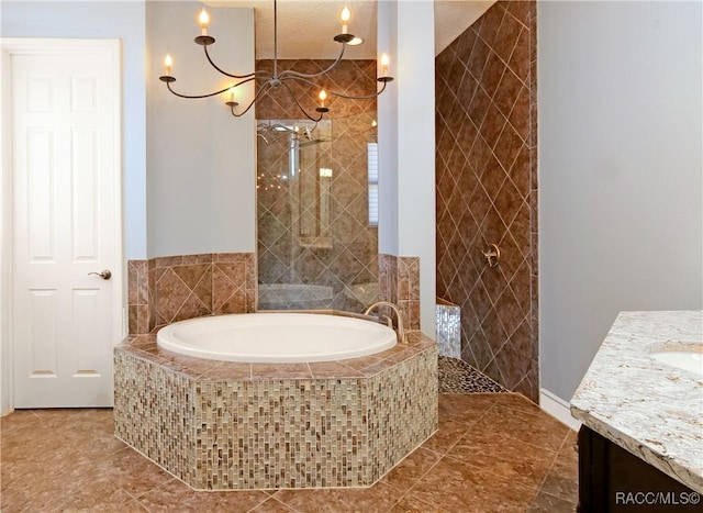 bathroom with tile patterned flooring, vanity, and tiled tub