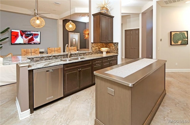 kitchen with pendant lighting, sink, stainless steel dishwasher, a kitchen island, and dark brown cabinetry