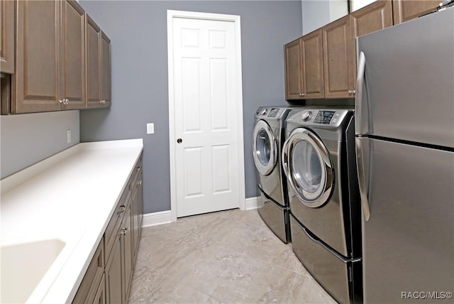 clothes washing area with cabinets, independent washer and dryer, and sink