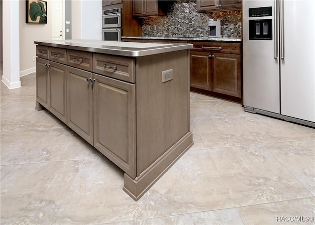 kitchen featuring decorative backsplash, a kitchen island, dark brown cabinets, and stainless steel appliances