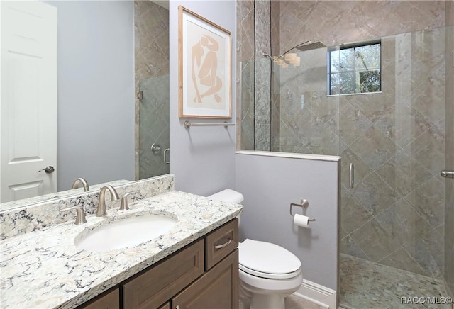 bathroom featuring vanity, toilet, and a shower with door