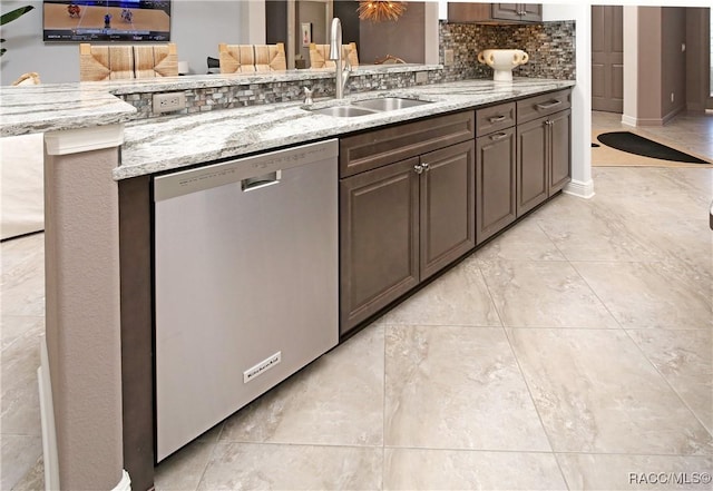 kitchen featuring backsplash, dark brown cabinetry, dishwasher, and sink