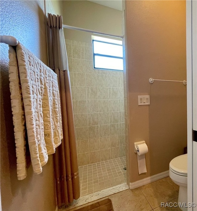 bathroom featuring tile patterned flooring, a shower with curtain, and toilet